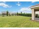 Expansive backyard with lush lawn, defined borders, and a view of neighboring houses at 8975 Fluffy Lie Ct, Davenport, FL 33896