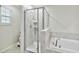 Modern bathroom showcasing glass shower, and a luxurious soaking tub, designed for ultimate comfort at 8975 Fluffy Lie Ct, Davenport, FL 33896