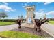 Community entrance featuring a decorative Golf & Tennis sign with professional landscaping at 8975 Fluffy Lie Ct, Davenport, FL 33896
