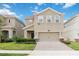 Inviting two-story home featuring a neutral color scheme, attached two car garage, and well maintained lawn at 8975 Fluffy Lie Ct, Davenport, FL 33896