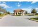 A gated community entrance with beautiful landscaping and mature trees at 8975 Fluffy Lie Ct, Davenport, FL 33896