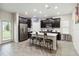 Modern kitchen featuring an island with barstool seating, stainless steel appliances, and dark cabinets at 8975 Fluffy Lie Ct, Davenport, FL 33896