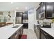 Modern kitchen with stainless steel appliances, dark cabinets, white countertop, and a kitchen island at 8975 Fluffy Lie Ct, Davenport, FL 33896