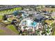 Aerial view of community pool and waterpark area with manicured landscaping, lounge areas, and ample parking at 8975 Fluffy Lie Ct, Davenport, FL 33896