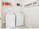 Functional laundry room with modern washer and dryer, plus storage shelf at 9106 Cut Shot Dr, Winter Garden, FL 34787