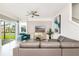 Bright living room featuring modern furniture, stylish decor, a ceiling fan, and sliding glass doors to the outside at 9106 Cut Shot Dr, Winter Garden, FL 34787