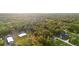 Panoramic aerial view of wooded acreage featuring homes with metal roofs and a matching metal barn at 920 Grand Ave, Orange City, FL 32763