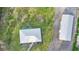 Aerial view of property featuring house with metal roof, metal barn, and circle pattern on the lawn at 920 Grand Ave, Orange City, FL 32763