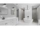 Modern bathroom featuring a soaking tub, walk-in shower, and white double vanity with marble countertops at 920 Grand Ave, Orange City, FL 32763