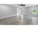 Spacious bedroom features wood-look floors, a ceiling fan, and natural light from the large windows at 920 Grand Ave, Orange City, FL 32763