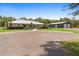 Charming single-story home with well-maintained landscaping and a circular driveway, plus a large garage or workshop in the background at 920 Grand Ave, Orange City, FL 32763