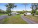 A single-story home featuring a well-kept lawn and a gray metal outbuilding in the back, all surrounded by tall trees at 920 Grand Ave, Orange City, FL 32763