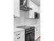 A well-equipped kitchen featuring white cabinets, a modern range hood, and sleek countertops, plus stainless steel appliances at 920 Grand Ave, Orange City, FL 32763