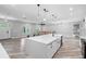 Open kitchen with a large island, white cabinets, stainless steel appliances, and modern pendant lighting at 920 Grand Ave, Orange City, FL 32763