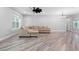 Bright living room featuring modern light fixture, ceiling fan, neutral color palette, and wood-look floors at 920 Grand Ave, Orange City, FL 32763