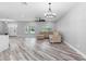 Light-filled living room features sleek wood-look floors, a modern light fixture and a comfortable neutral sectional at 920 Grand Ave, Orange City, FL 32763