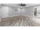 Spacious main bedroom features wood-look floors, a ceiling fan, and an ensuite bathroom with a soaking tub at 920 Grand Ave, Orange City, FL 32763
