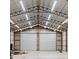 Bright outbuilding interior featuring high ceilings, metal framing, and convenient garage doors at 920 Grand Ave, Orange City, FL 32763