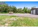 Exterior view of the outbuilding with metal siding and large garage doors, sitting on open land at 920 Grand Ave, Orange City, FL 32763