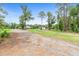 Landscaped view of property with driveway leading to home and outbuilding in the background at 920 Grand Ave, Orange City, FL 32763