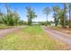 Lush, green property view featuring a long driveway leading to the home and outbuilding at 920 Grand Ave, Orange City, FL 32763