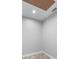 A gray unfinished room with an access hatch, gray walls, laminate flooring, and one electrical outlet at 920 Grand Ave, Orange City, FL 32763