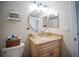 The bathroom includes a granite countertop vanity, round mirror, stacked towels and toilet at 952 Courtyard Ln # 41, Orlando, FL 32825