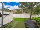 Backyard features an artificial grass area, a privacy fence, and lush green trees at 9539 Silver Buttonwood St, Orlando, FL 32832