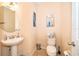 Cozy half bathroom with a pedestal sink, decorative artwork, and well-maintained fixtures at 9539 Silver Buttonwood St, Orlando, FL 32832
