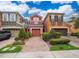 Charming townhomes with brick driveways, well-kept lawns, and attached garages under a bright blue, partly cloudy sky at 9539 Silver Buttonwood St, Orlando, FL 32832