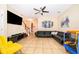 Inviting living room with a sectional sofa, tiled floors, ceiling fan, staircase, and ample natural light at 9539 Silver Buttonwood St, Orlando, FL 32832
