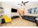 Comfortable living room featuring a sectional sofa, tiled floors, ceiling fan, and a modern entertainment center at 9539 Silver Buttonwood St, Orlando, FL 32832