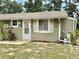 Charming single-story home featuring light green siding, a welcoming front door, and well-maintained landscaping at 10301 Us Highway 27 # 34, Clermont, FL 34711