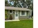 Charming single-story home featuring light green siding, a well-manicured lawn, and a welcoming front entrance at 10301 Us Highway 27 # 34, Clermont, FL 34711