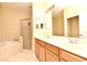 Bathroom featuring double vanity, large mirror, glass shower, and separate tub for added convenience at 1086 Wickerwood St, Ocoee, FL 34761