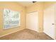 Bedroom with beige carpet, double door closet, and window with blinds at 1086 Wickerwood St, Ocoee, FL 34761