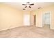 Large bedroom with neutral carpet, a ceiling fan, and multiple doorways to an ensuite and walk-in closet at 1086 Wickerwood St, Ocoee, FL 34761