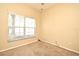 Neutral painted empty bedroom features a window with blinds and carpeted flooring at 1086 Wickerwood St, Ocoee, FL 34761