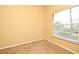 A bedroom with beige carpet, a window with blinds and light yellow walls at 1086 Wickerwood St, Ocoee, FL 34761