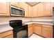 Kitchen with wood cabinets and black microwave and range at 1086 Wickerwood St, Ocoee, FL 34761