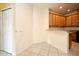 An open area with tiled floors, leading to a kitchen featuring light wooden cabinets at 1086 Wickerwood St, Ocoee, FL 34761