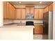 Open kitchen with wood cabinets, gray countertops, and stainless steel refrigerator at 1086 Wickerwood St, Ocoee, FL 34761
