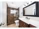 Bathroom featuring a vanity with marble countertop, a framed mirror, and a tiled walk-in shower at 1115 Marni Ridge Ct, Kissimmee, FL 34747