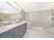 Bathroom with double sinks, marble countertops, tiled walls, and a glass shower at 1115 Marni Ridge Ct, Kissimmee, FL 34747