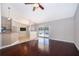 Open-concept living room with bar and kitchen views, hardwood floors, and pool access at 1115 Marni Ridge Ct, Kissimmee, FL 34747