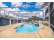 Backyard pool with screened enclosure, complemented by a concrete patio and a lion statue at 1115 Marni Ridge Ct, Kissimmee, FL 34747