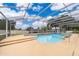 Screened-in pool with a spa, integrated steps, and tile accents surrounded by an expansive patio at 1115 Marni Ridge Ct, Kissimmee, FL 34747