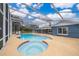 Enclosed swimming pool and spa with an extended patio area, connecting seamlessly to the home at 1115 Marni Ridge Ct, Kissimmee, FL 34747