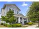 Charming two-story home with a welcoming front porch, white columns, blue door, and lush landscaping at 1206 Civitas Way, Winter Garden, FL 34787