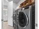 Well-equipped laundry room with modern washer, dryer, shelving and adjacent to the a full bathroom at 1206 Civitas Way, Winter Garden, FL 34787
